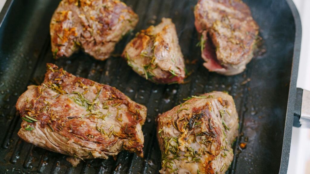 Searing diced chicken thighs in a pan for maximum flavor.