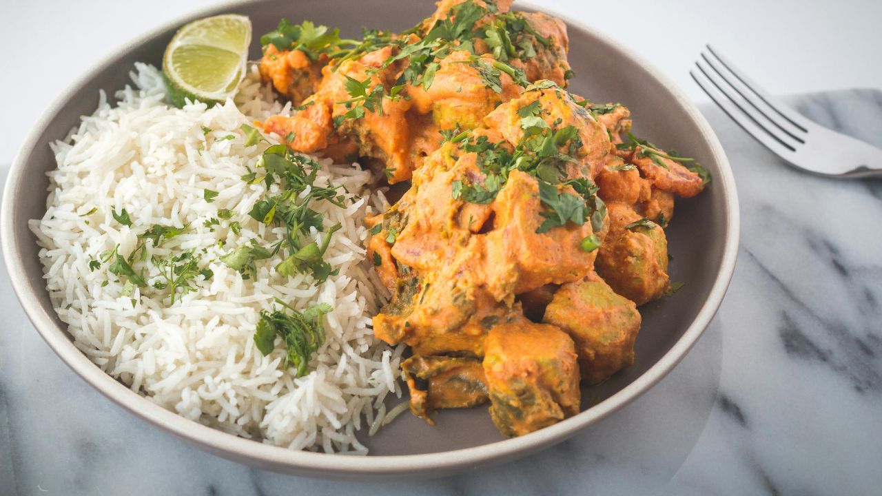 A golden-brown chicken and wild rice casserole in a white ceramic dish.