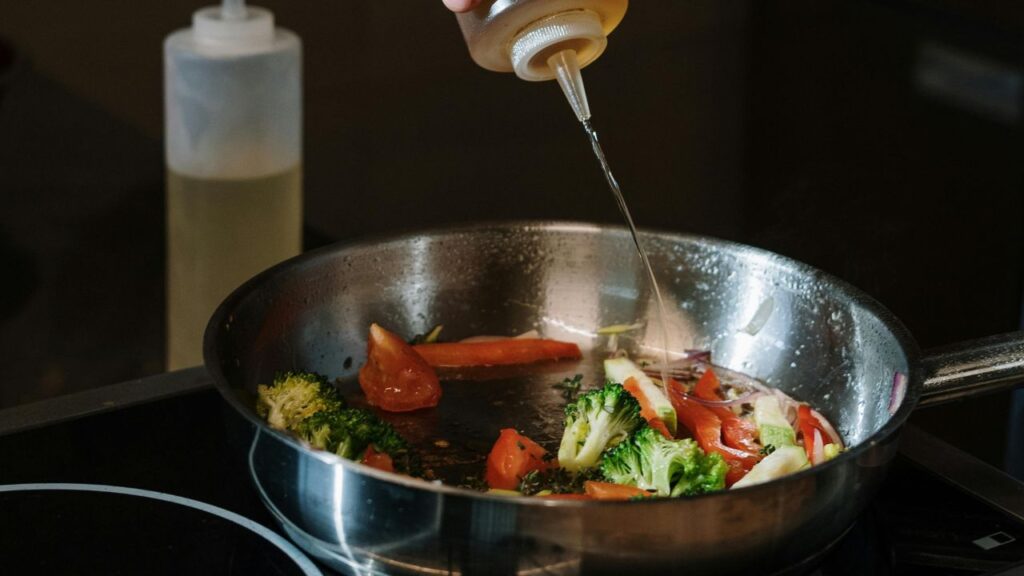 Slicing and sautéing aromatics as a first step in cooking with chili peppers for a homemade infusion.