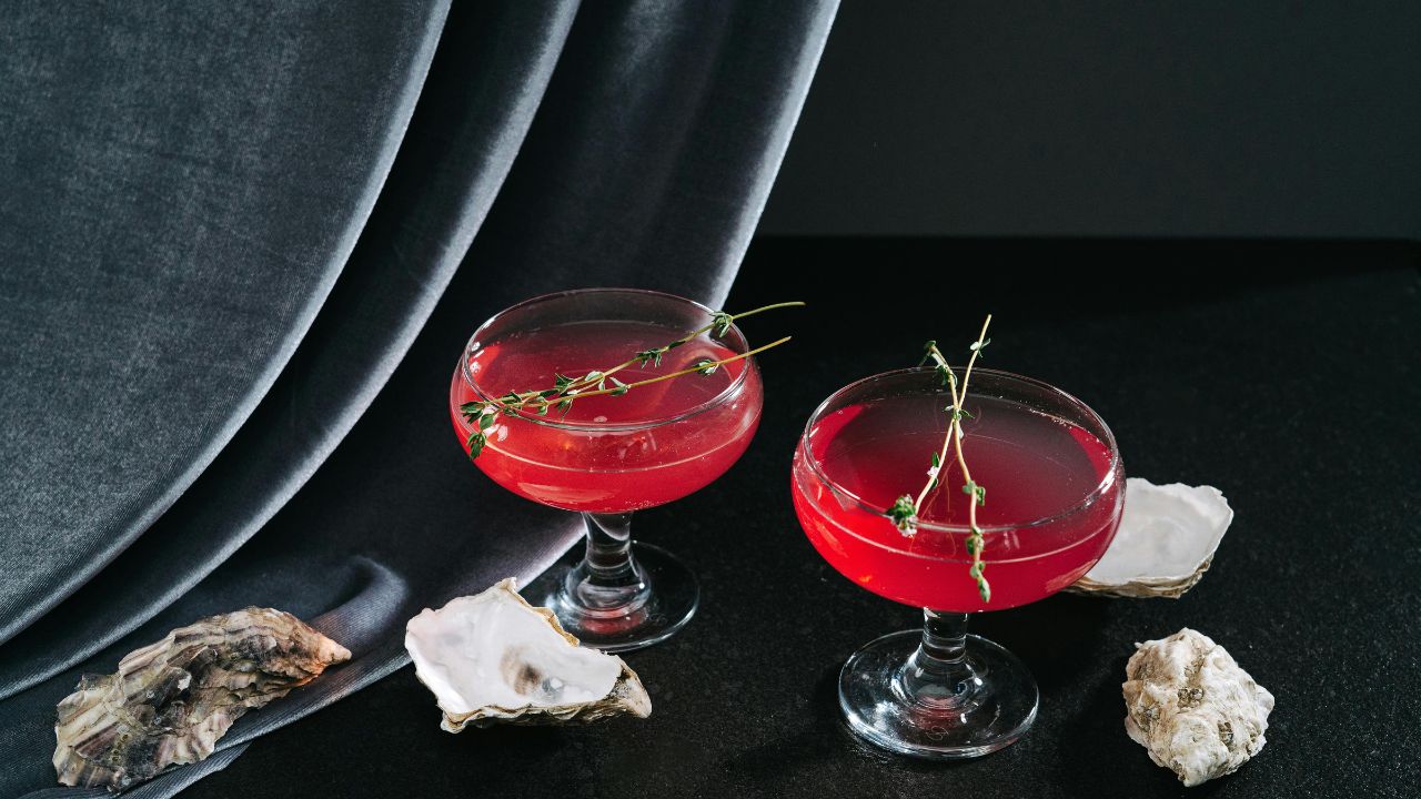 A vibrant purple-pink candy cocktail in a sugared coupe glass