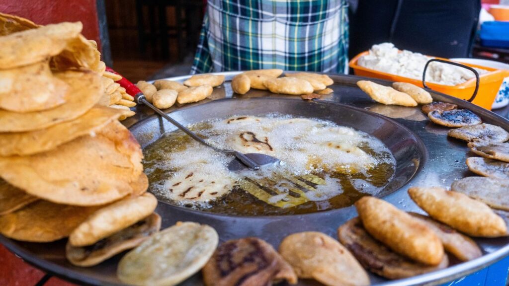 Close-up of golden brown chicken nuggets frying in a pan to show perfect texture and oil temperature.
