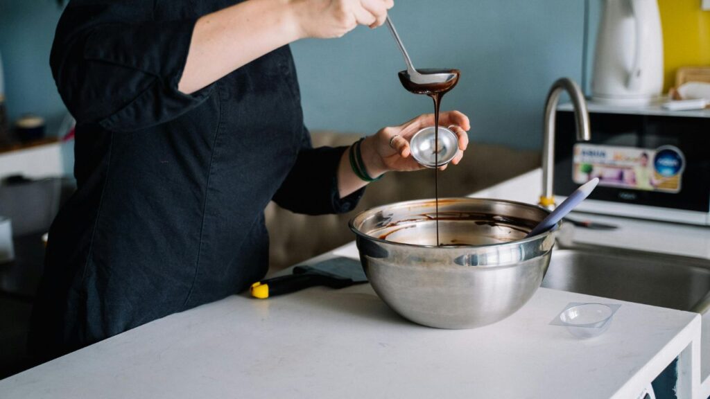 Chocolate melting into warm milk in saucepan